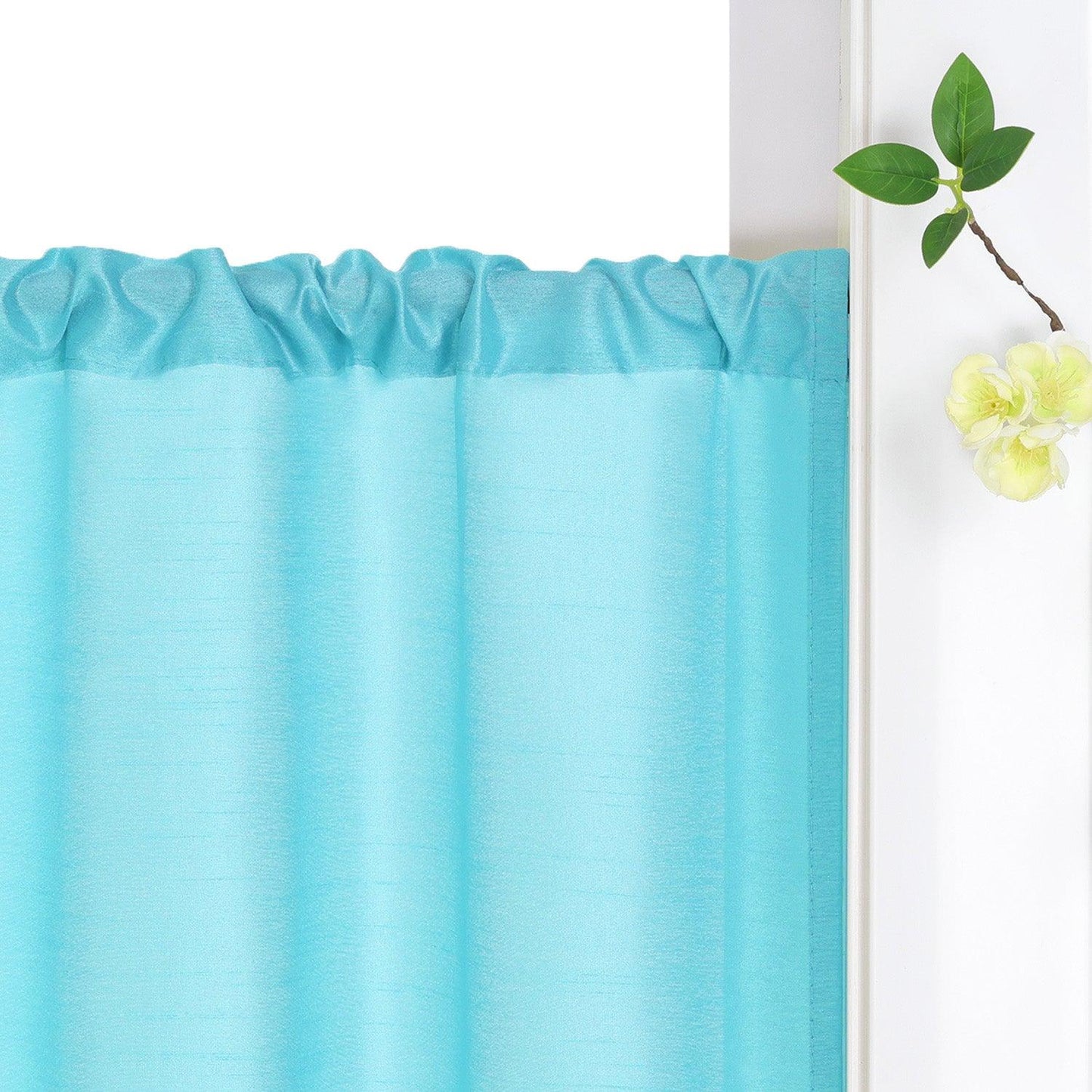 Der blaue Vorhang ist an der Gardinenstange aufgehängt und fällt natürlich in sanften Falten. Neben dem Vorhang befinden sich dekorative Blumen, die dem Raum eine frische und elegante Atmosphäre verleihen.