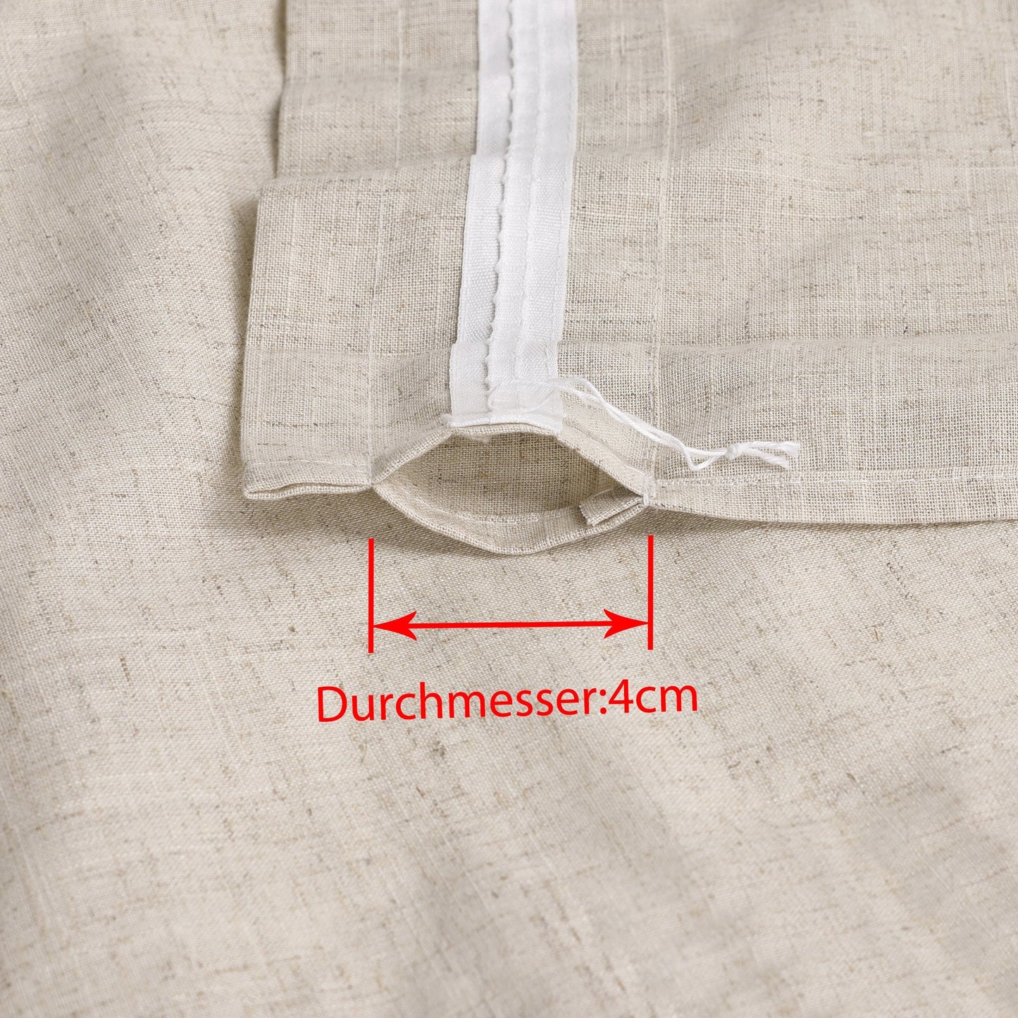 Dies ist ein Detailbild des Vorhangstoffs, das den Bereich des Vorhangs mit der Aufhängung zeigt. Der Durchmesser des Durchzugslochs beträgt 4 cm, was die Anpassung an Vorhangstangen der entsprechenden Größe erleichtert. Der Stoff hat eine cremeweiße Farbe und erinnert an Leinen.