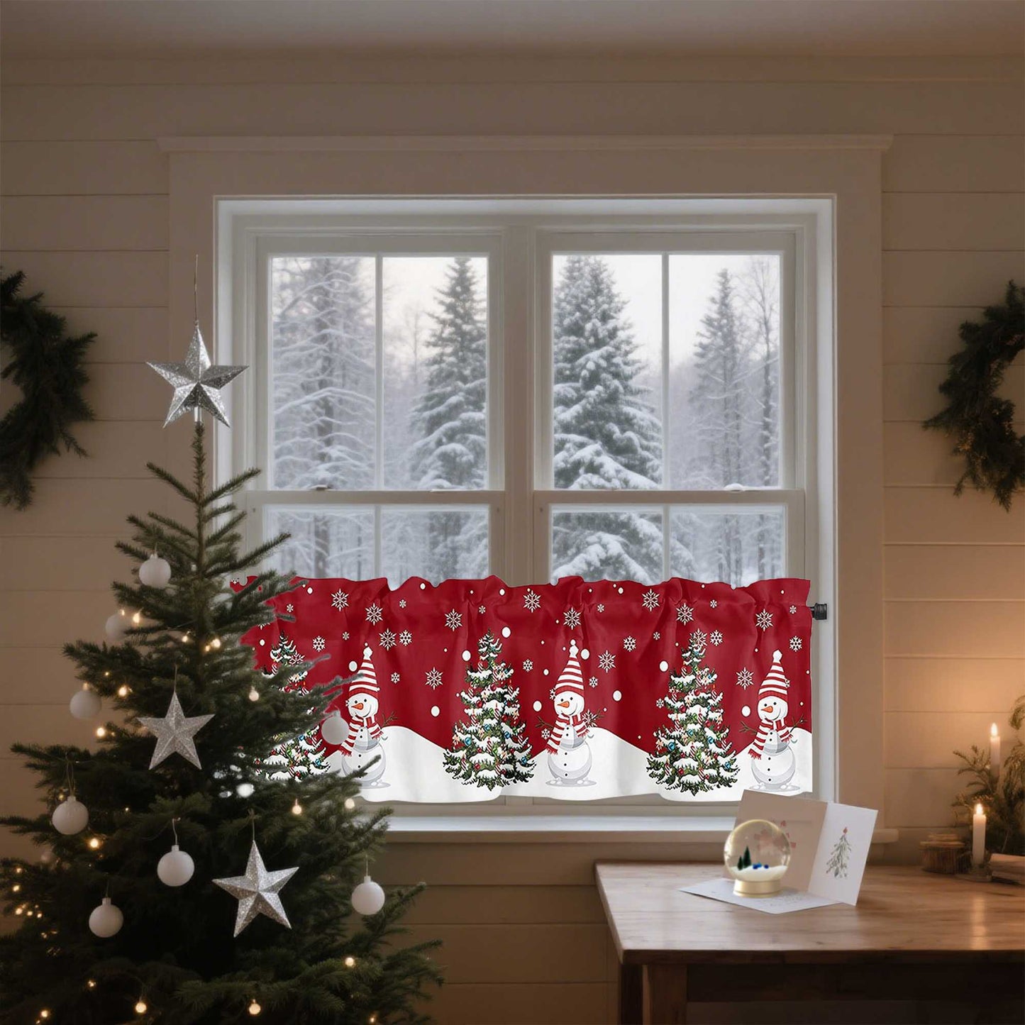 Das Bild zeigt ein gemütliches Zimmer mit einem weihnachtlich dekorierten Fenster. Der Vorhang ist in Rot gehalten und zeigt festliche Schneemänner, die mit Schals und Hüten geschmückt sind, sowie Tannenbäume, die mit Schneeflocken verziert sind. Durch das Fenster ist eine verschneite Landschaft mit hohen Bäumen sichtbar. Im Vordergrund steht ein Weihnachtsbaum mit silbernen Sternen und Kugeln, und auf dem Tisch liegt eine kleine weiße Weihnachtskarte.