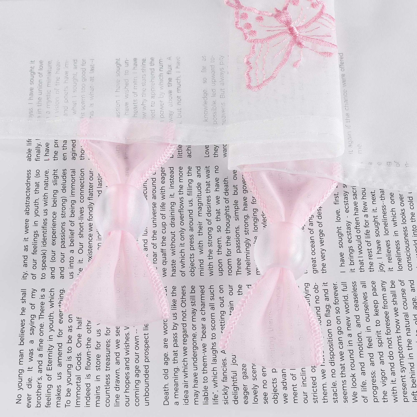 Nahaufnahme der transparenten Perlen, die an der oberen rosa Aufhängeschlaufe des Vorhangs befestigt sind, wobei die Perlen direkt mit der Schlaufe verbunden sind.