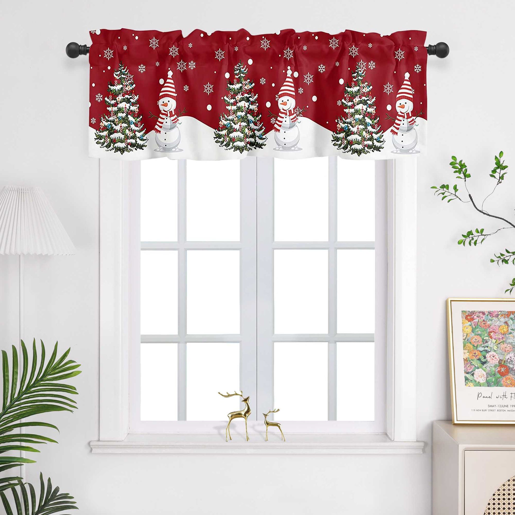 Diese rote Weihnachts-Scheibengardine mit festlich gestalteten Weihnachtsbaum- und Schneemann-Motiven bringt sofort eine warme, weihnachtliche Atmosphäre in Ihr Zuhause. Der rote Hintergrund hebt die detaillierten Schneemänner und den Weihnachtsbaum hervor, die von kleinen, zarten Schneeflocken umgeben sind, die sanft durch den Stoff gleiten. Die Lichtschutzgardine hängt vor einem weißen Fenster, und die weiße Wand sowie die grünen Pflanzen im Raum ergänzen das Design perfekt und schaffen eine harmonische u