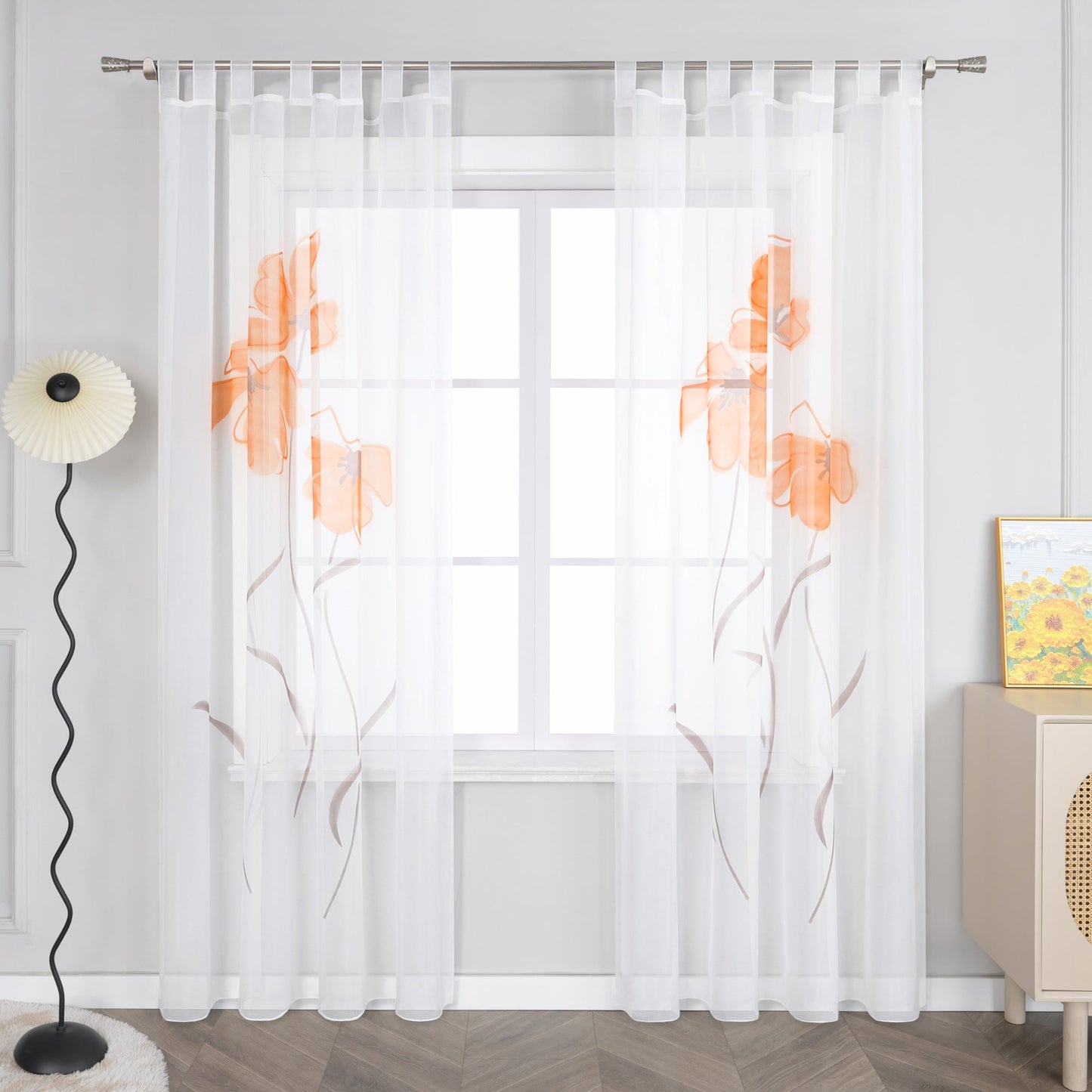 Das Bild zeigt einen Vorhang mit orangefarbenen Blumenmustern. Der Vorhang ist hauptsächlich weiß, wobei die Blumen im Muster orangefarbene und braune Details aufweisen.