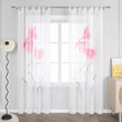 Das Bild zeigt einen weißen Vorhang, der an einem Fenster hängt, mit einem Muster aus rosa Blumen und braunen Zweigen. Der Vorhang ist mit Schlaufen an einer Metallstange befestigt. Neben dem Fenster steht eine Stehlampe mit einem schwarzen, gebogenen Stab und einem weißen, fächerförmigen Lampenschirm. Daneben befindet sich ein heller Schrank, auf dem ein Bild steht.