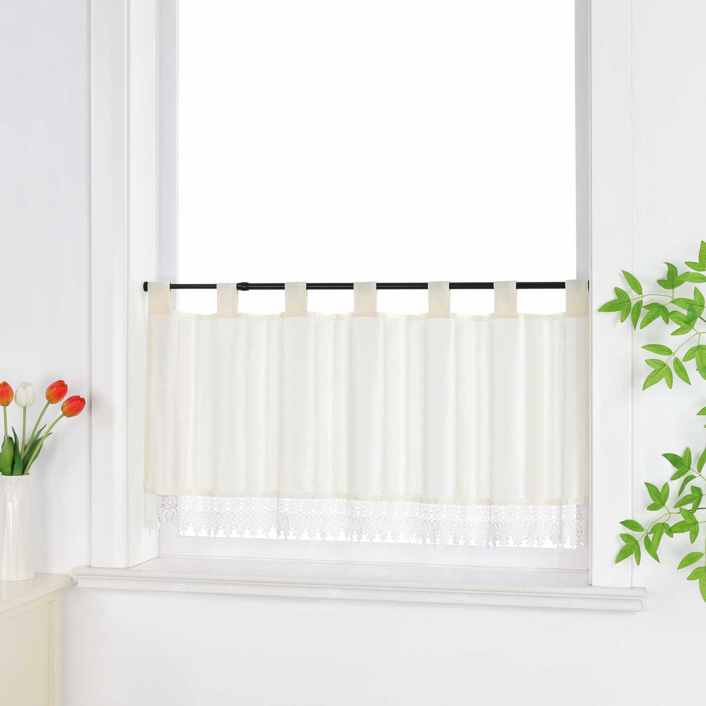 Seitlich aufgenommene scheibengardine beige vor dem Fenster, dekoriert mit grünen Blättern und Blüten.