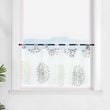 Die transparente Scheibengardine mit braunen Feuerwerksmotiven hängt elegant vor einem Fenster. Die weiße Wand im Hintergrund lässt die braunen Muster des Feuerwerks besonders hervorstechen und sorgt für eine ruhige, festliche Atmosphäre im Raum.